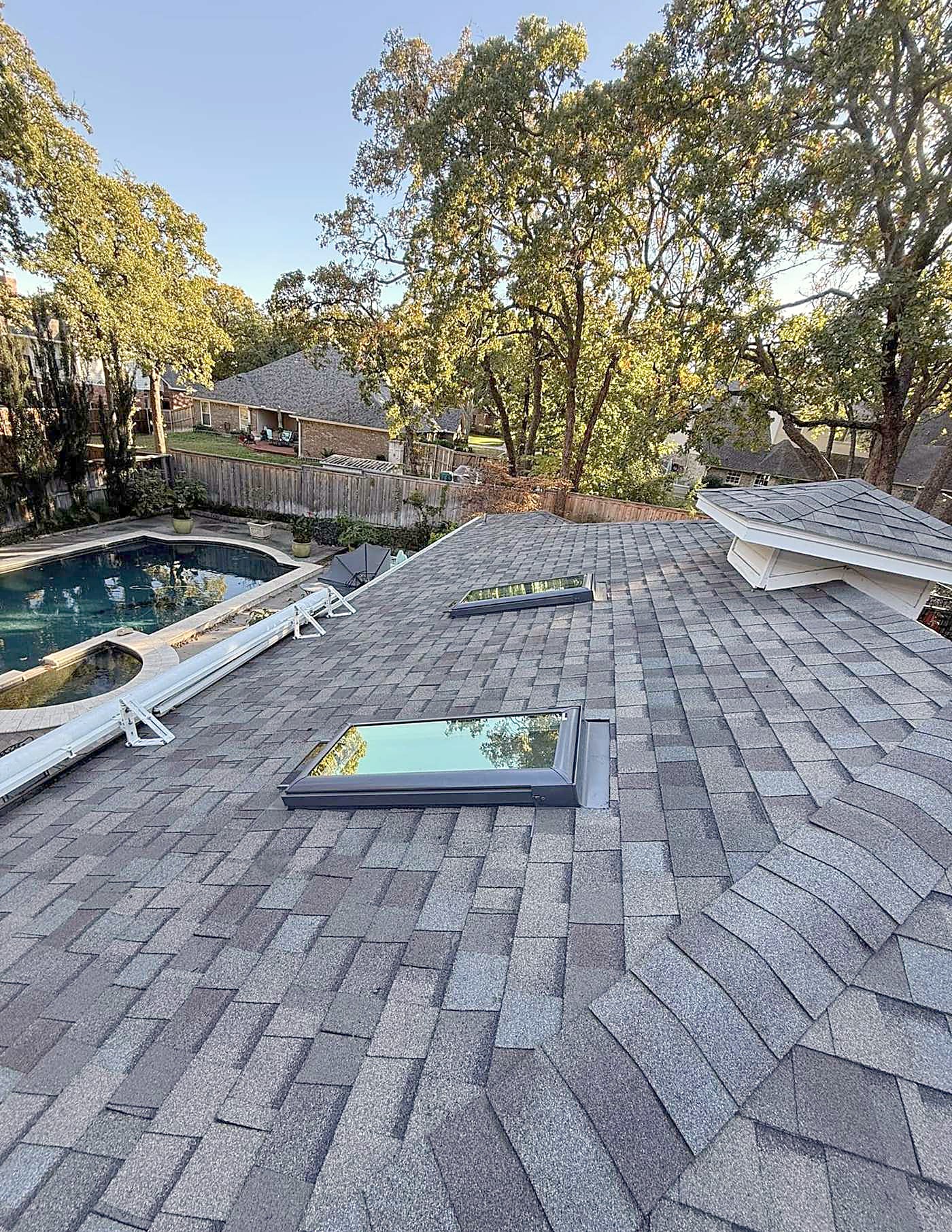 Two skylights set into a shingle roof above a pool deck