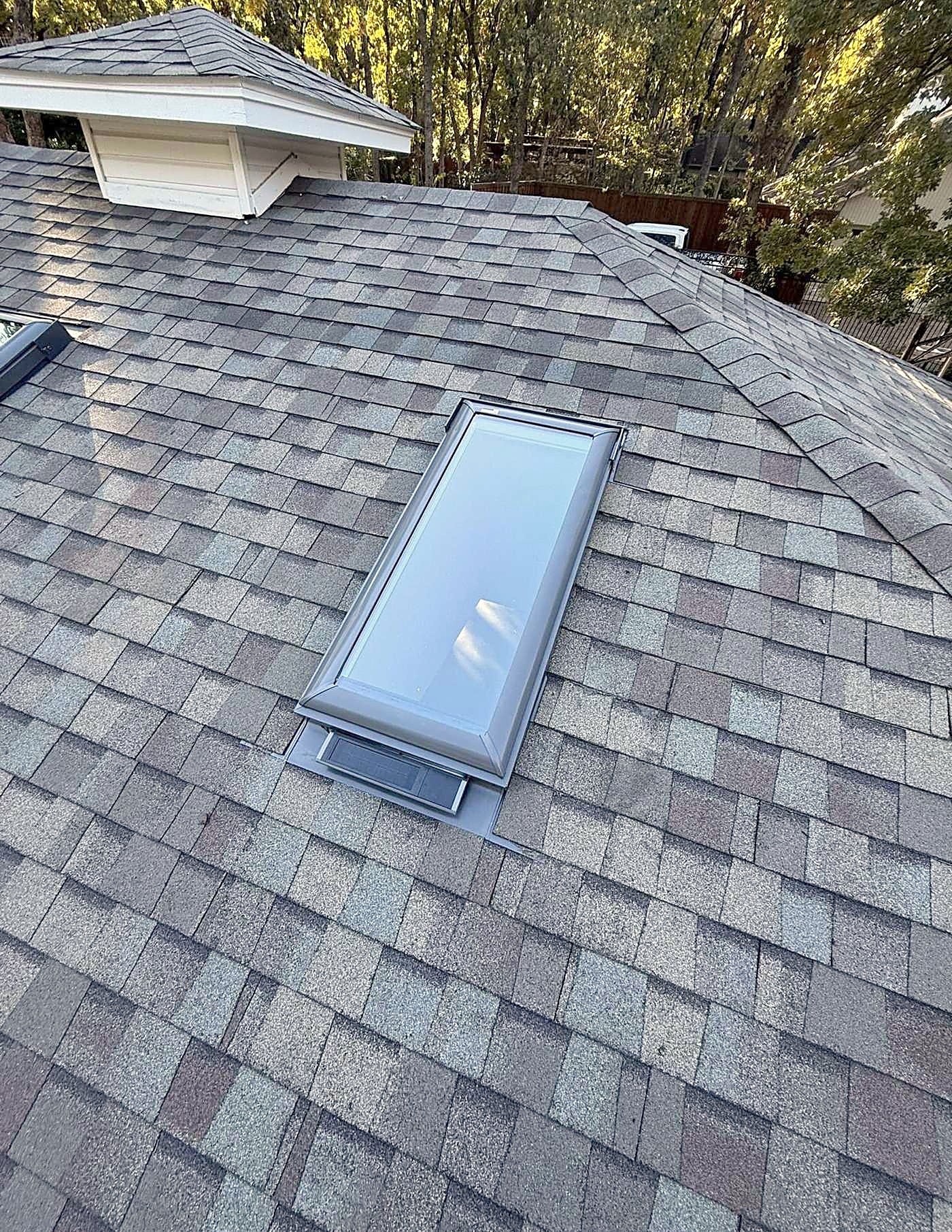 A skylight set into a finished shingle roof